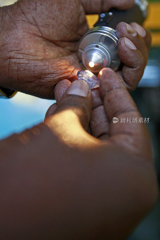 斯里兰卡矿工检查一颗宝石