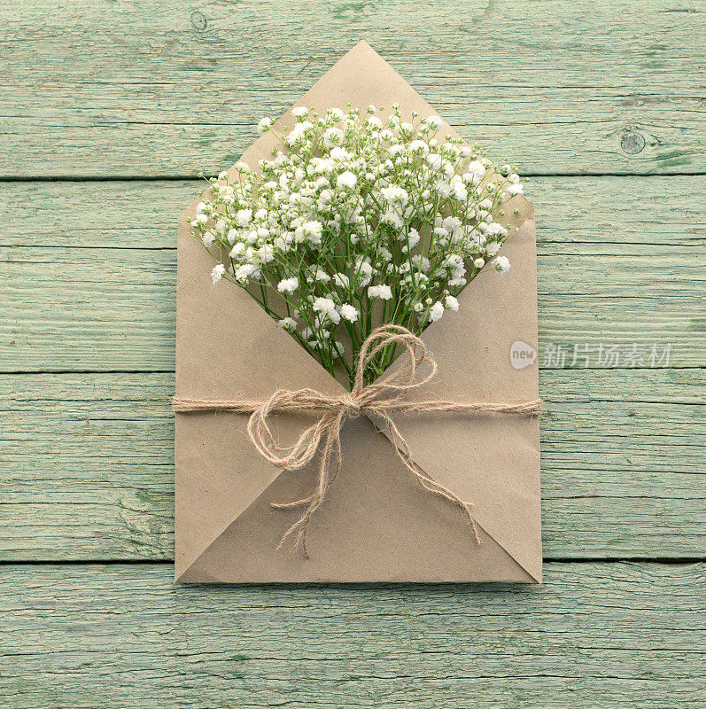 美丽的花朵装在信封里，木质的背景