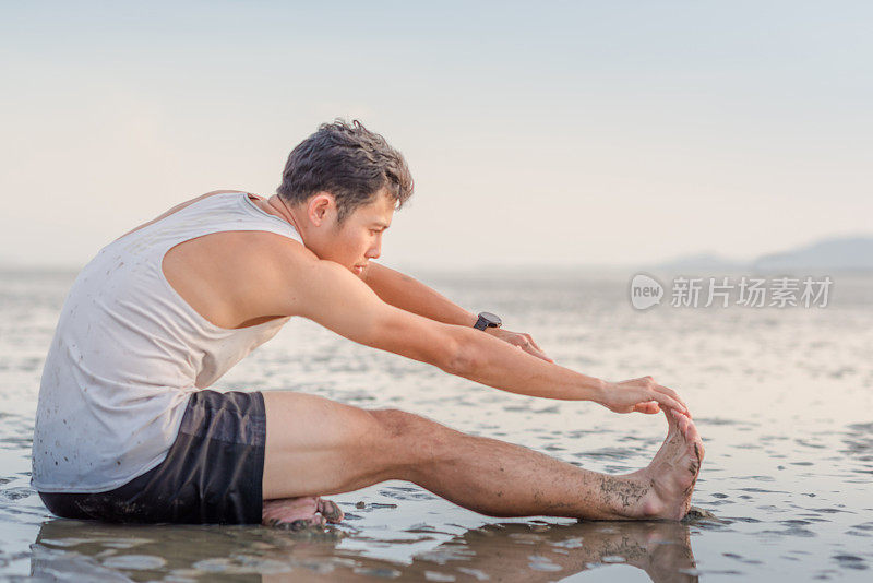 年轻的亚洲男子在日落海滩做瑜伽运动