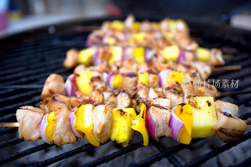 烤架上的鸡肉、洋葱和菠萝串