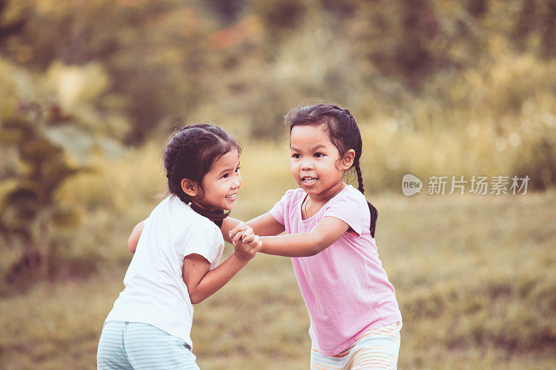 两个亚洲小女孩在公园里一起玩