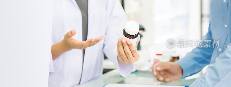 女性药剂师手持药瓶在药店或药店向顾客提供建议