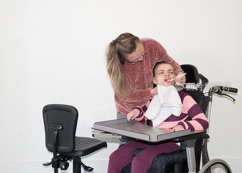 一名坐在轮椅上的残疾儿童和一名志愿护理人员在一起
