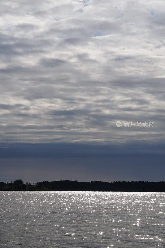 阳光照在湖面上。眩目天空的云彩。水和光对比