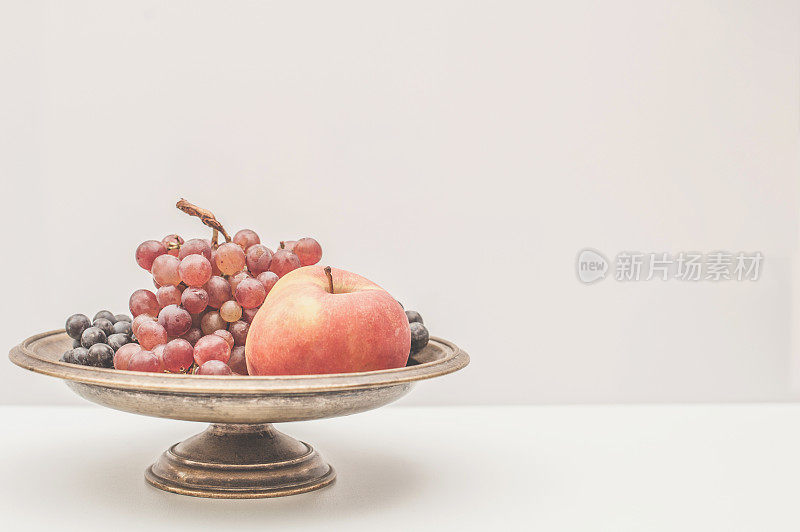 秋季静物与红葡萄和苹果在金属脚碗