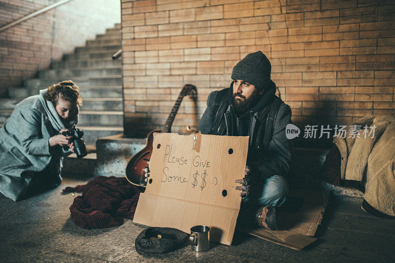 一个女人在街上拍乞丐