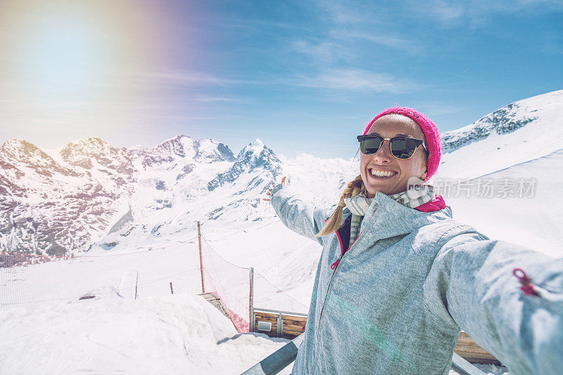 年轻女子从瑞士山顶自拍，滑雪度假享受瑞士阿尔卑斯山和度假概念滑雪斜坡