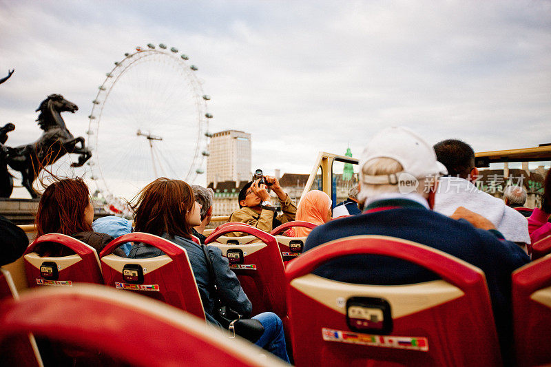 在伦敦，游客们享受着乘坐观光巴士的乐趣