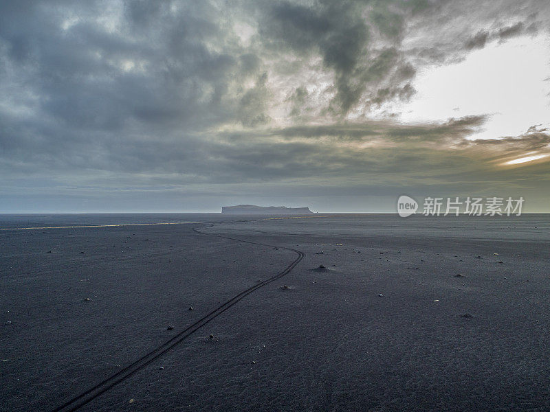 日落时分，冰岛天空映衬着黑色的火山沙
