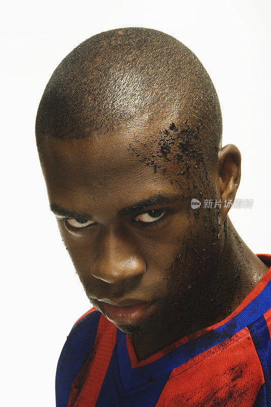 非裔美国男子足球运动员，脸上有泥土