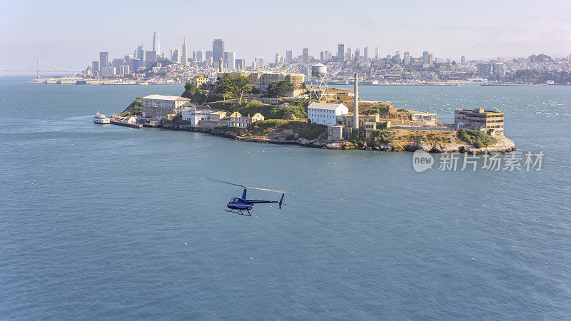 直升机沿着恶魔岛飞行的鸟瞰图，以旧金山为背景