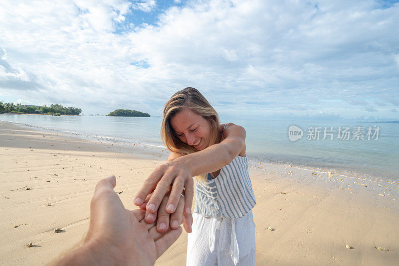 跟我来概念女人领先的男朋友在泰国田园海滩。人们旅行豪华度假目的地的概念