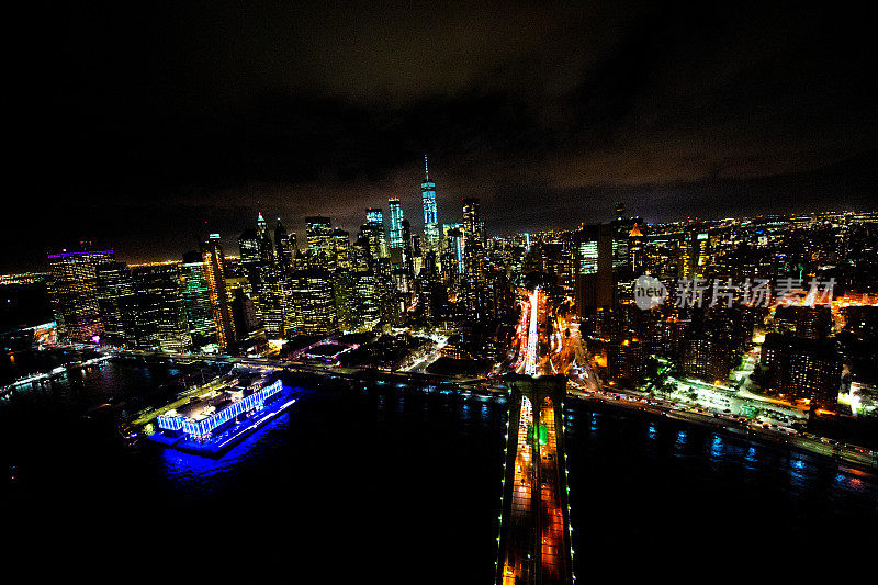 夜间东河上的布鲁克林大桥，从布鲁克林一侧拍摄，曼哈顿下城和世界贸易中心一号在城市界线之外可见