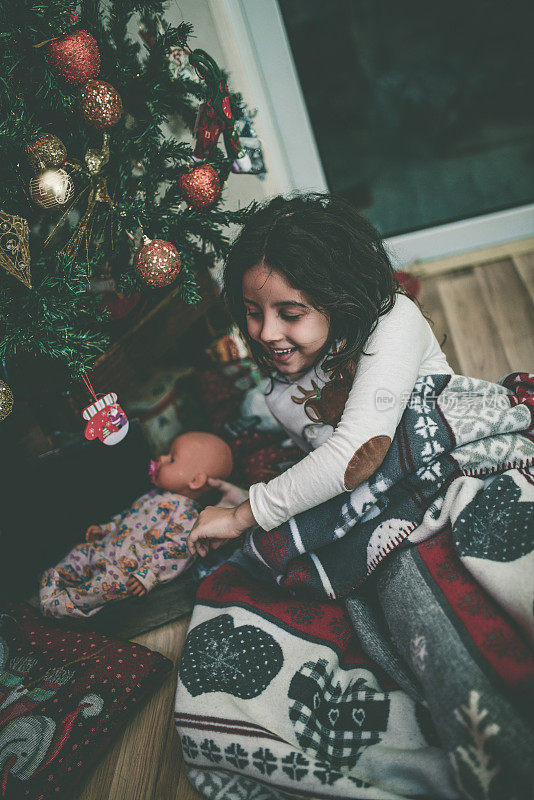 小女孩在圣诞树下享受