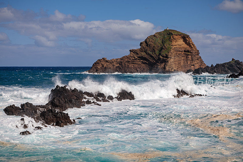 在多岩石的海岸上击碎波浪