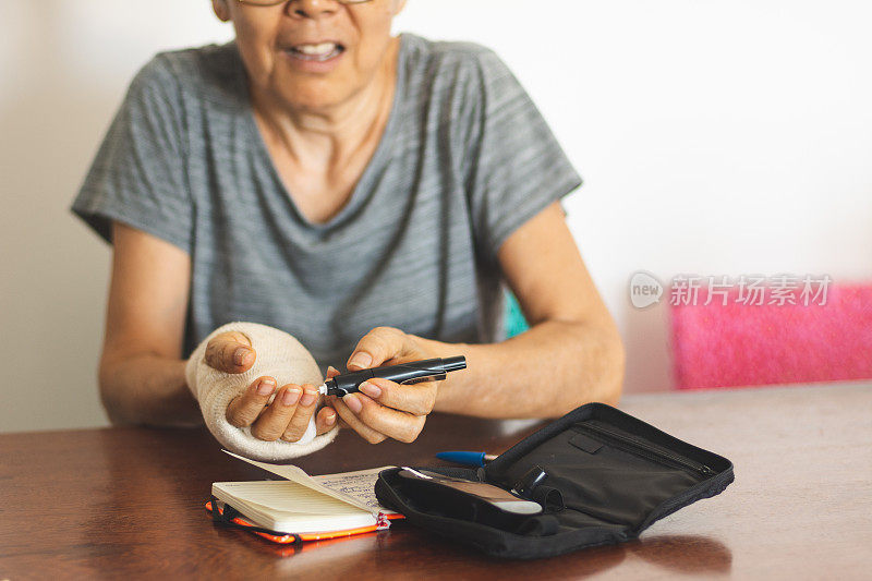 老年妇女在家用血糖仪检查血糖水平