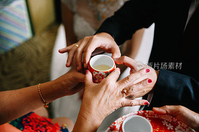 新婚夫妇在中国传统茶道上给老人斟茶