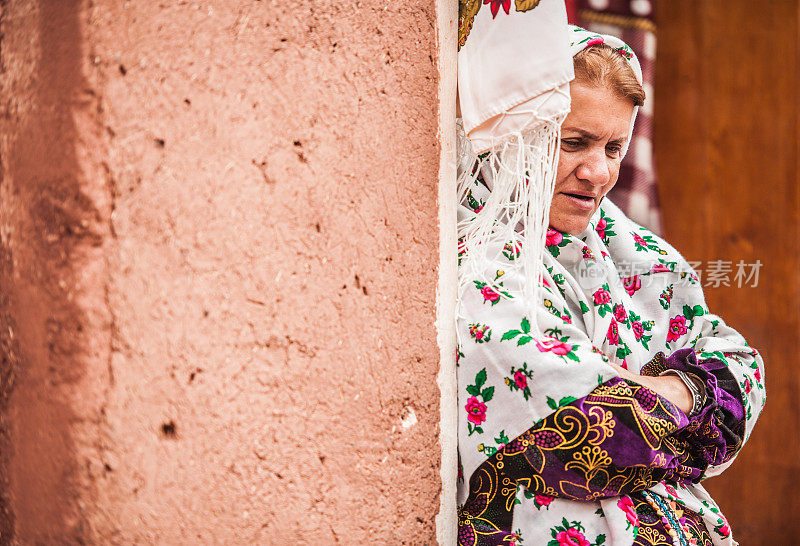身着伊朗传统服饰的美丽老妇人在伊朗阿比尼亚古村落的街道上摆姿势