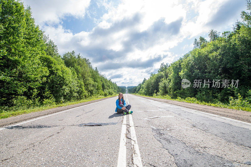 坐在乌拉尔山脉路上的年轻女子，佩尔姆，俄罗斯