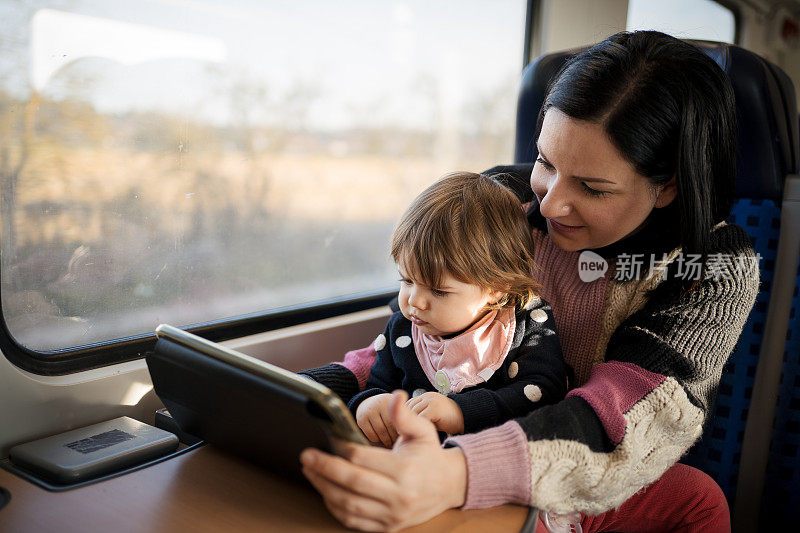 一位年轻的母亲带着她的孩子乘火车旅行，穿过美丽的风景