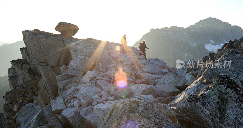 两名登山运动员在日出时横越山脊