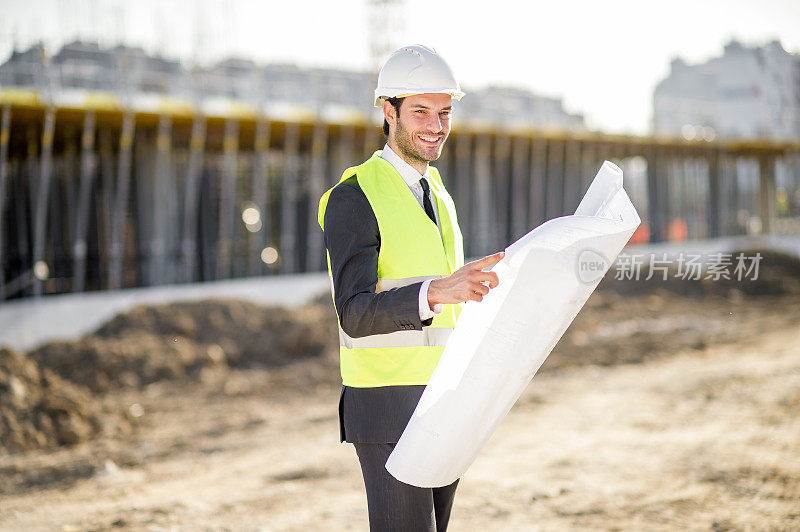 侧视图的年轻建筑工程师与项目和安全帽