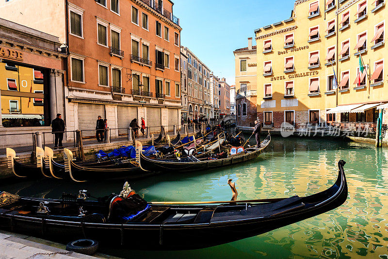 威尼斯狭窄运河码头上典型的威尼斯贡多拉