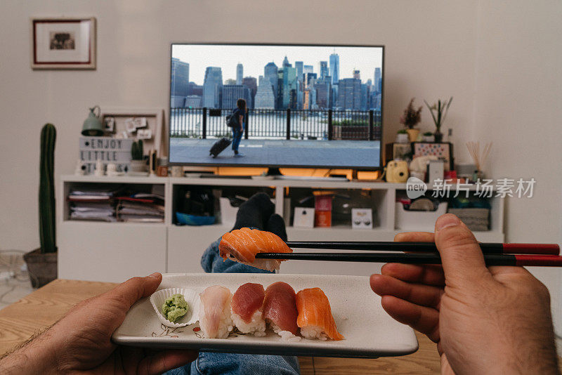 男人一边吃寿司一边看电视电影