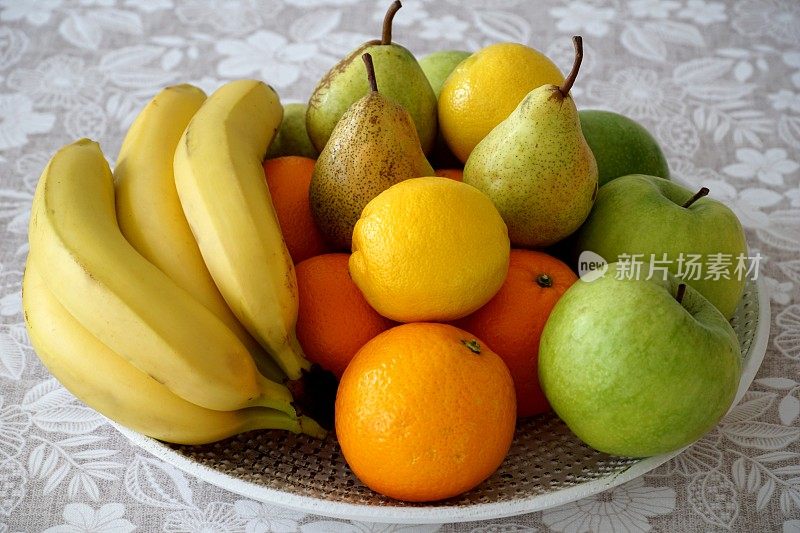 水果在盘子里。各种美味的水果富含维生素和抗氧化剂，黄柠檬和香蕉，青苹果和梨和橙子橙子
