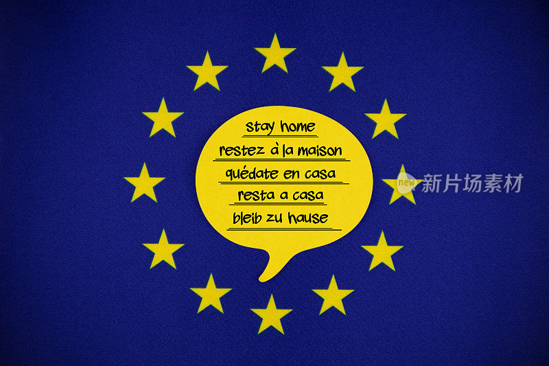 在欧盟旗帜上用欧洲语言写着留在家里的信息的白色演讲泡泡纸