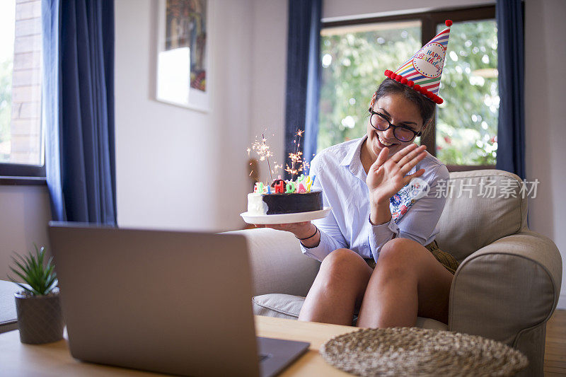 年轻美丽开朗的女性正在视频通话中问候生日