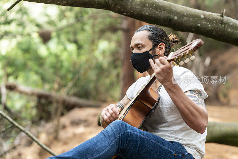 一个拉丁人在森林里独自弹吉他