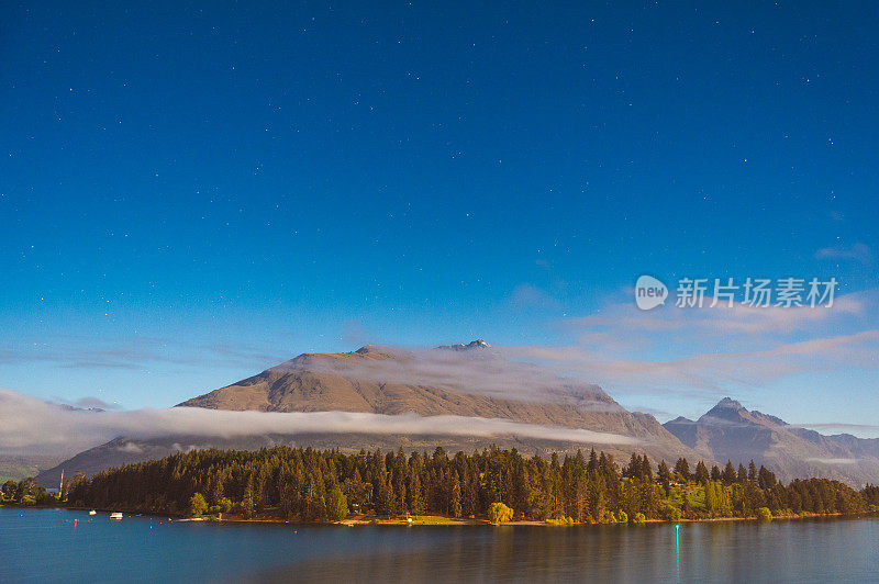 夜景观光银河星空自然景观皇后镇CBD区覆盖在夜晚的雾和云，看到许多住宅和度假山新西兰南岛