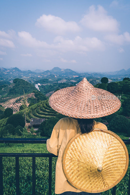 美丽的特写，一个女性靠在篱笆在亚洲锥形帽子靠山