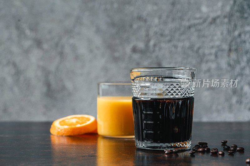 有选择地将冷萃咖啡放在玻璃杯中，靠近橙汁和咖啡豆