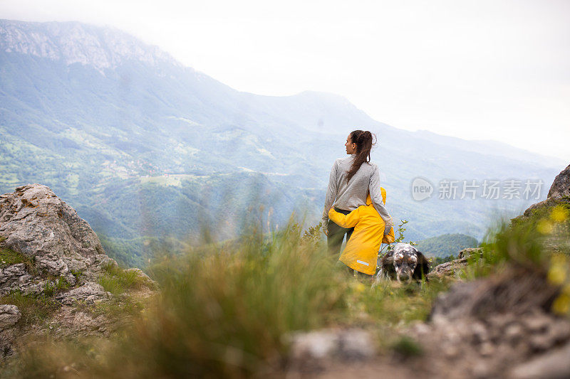 妈妈和儿子停下来欣赏风景，同时带着他们的狗徒步旅行