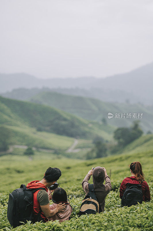 亚洲华人游客在卡梅伦高原茶园享受清晨的自然美景和清新空气，与家人合影