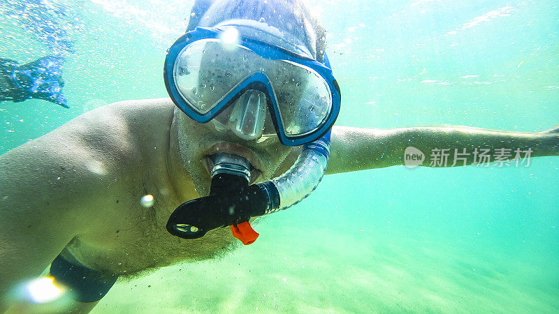 夏天，在法国布列塔尼海岸的浅水里浮潜的人