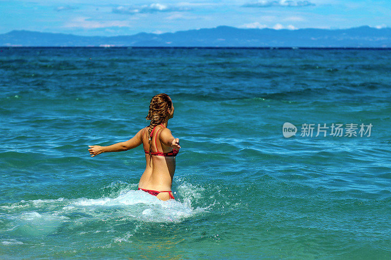 年轻女子享受在海滩上的一天