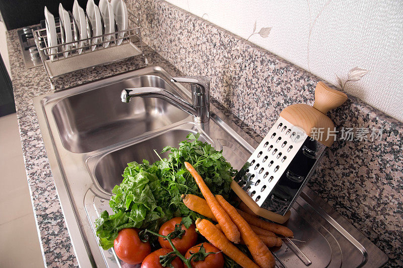 用水槽在厨房台面上洗干净的蔬菜
