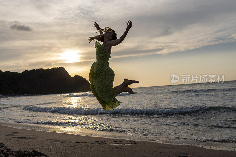 快乐的女人拿着帽子跑着跳着尽情享受海滩度假的生活。沙滩、夏日、liftstyle、积极心情、旅游、放松的概念。