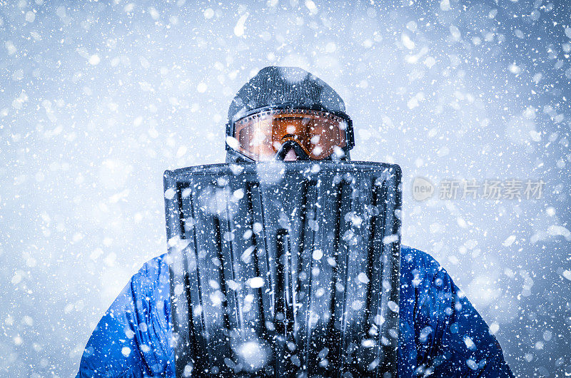 在暴风雪中戴着护目镜和铲子的人