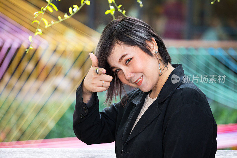 自信的年轻泰国女人用食指指着