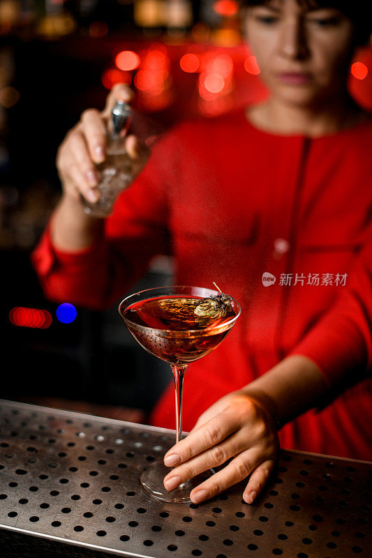 酒花装饰的酒杯立在吧台上，女人的手握着它