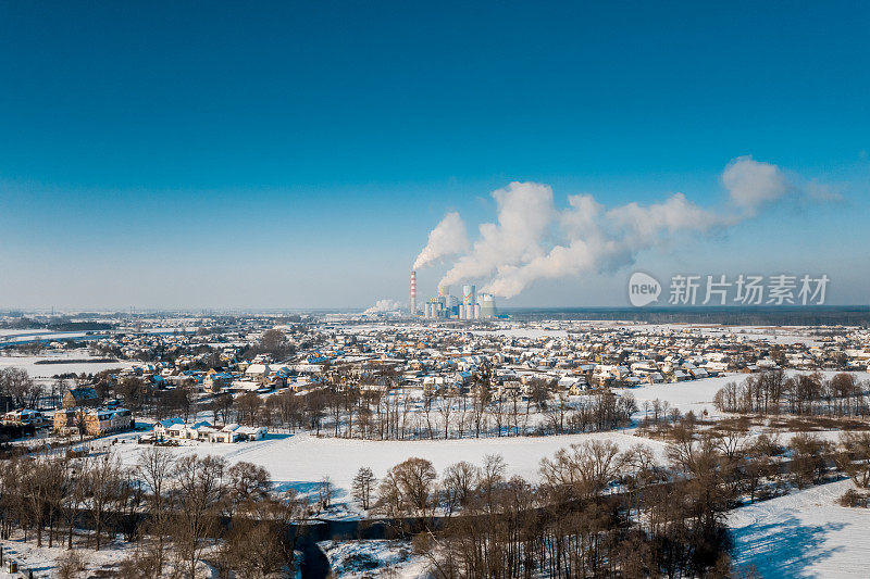 鸟瞰积雪覆盖的小镇、河流和一座燃煤电厂