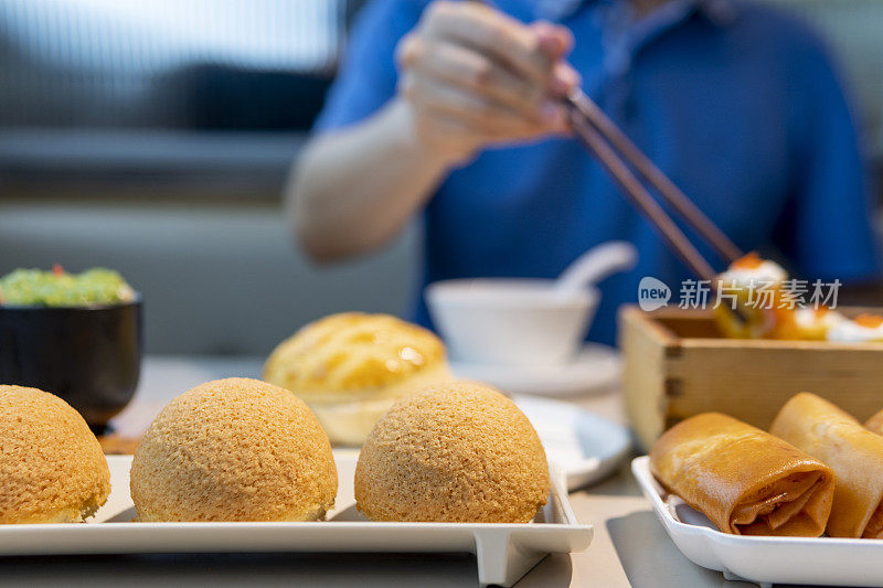 一名男子在餐馆用筷子吃广东点心