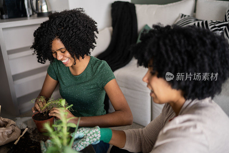 母亲和女儿在家里一起照料植物