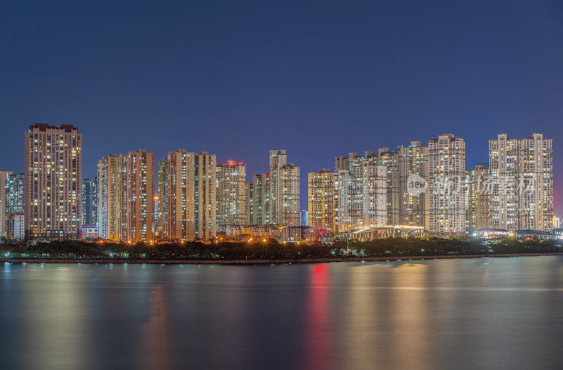 夜晚，现代城市的居住区临湖而过