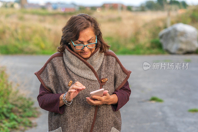 西班牙裔老年妇女边走边发短信
