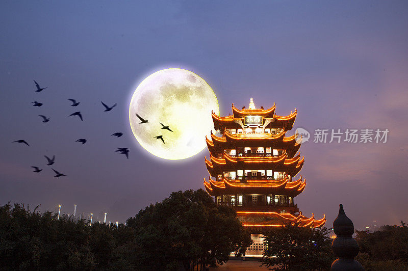 中秋节的夜晚灯火辉煌的黄鹤楼上挂着一轮明月